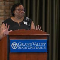 GVSU CECI dean gives speech into microphone on podium with the GVSU logo